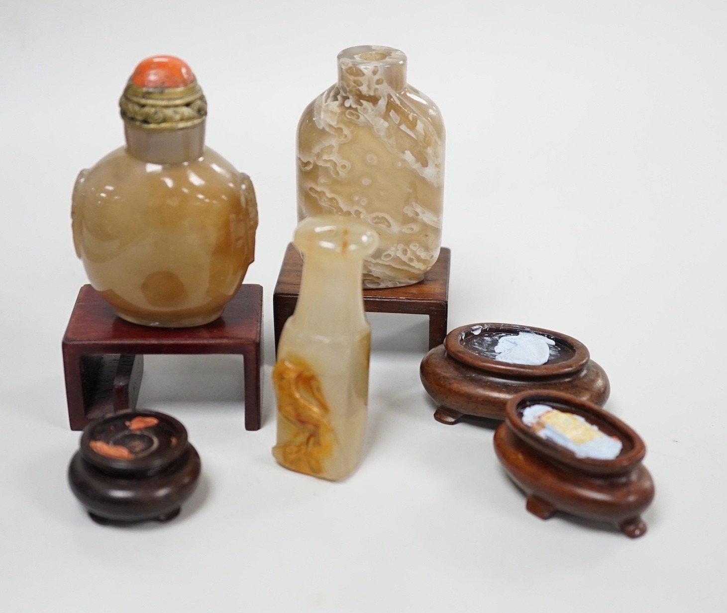 A Chinese chalcedony dendritic chalcedony (macaroni agate) snuff bottle, 5.7cm and a honey coloured agate mask and ring handled snuff bottle, 4.7cm, brass and coral stopper, both 1780-1880, together with a cameo agate pi